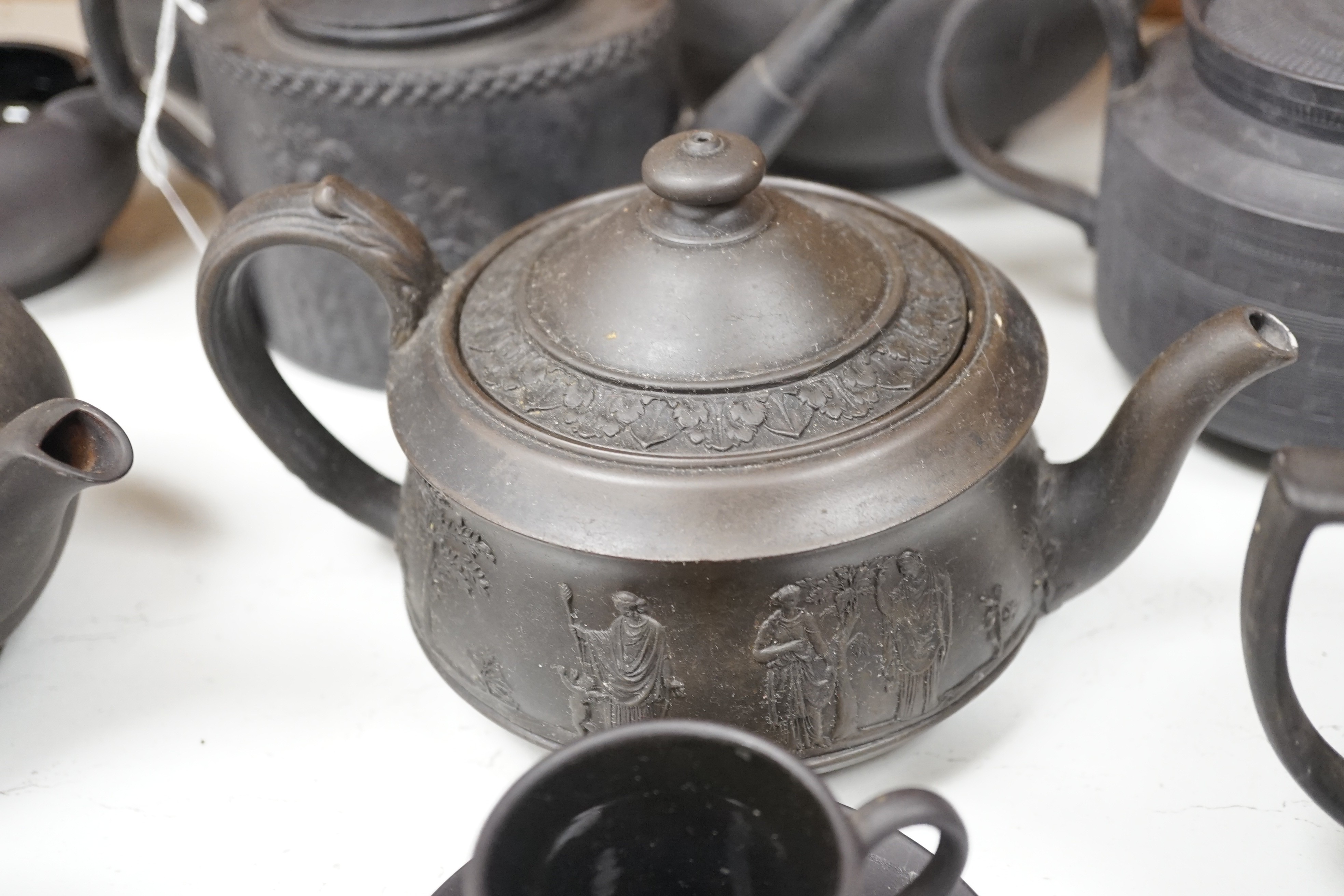 A collection of Wedgwood and other black basalt teapots and tea wares, 19th/early 20th century, tallest teapot 17cms high